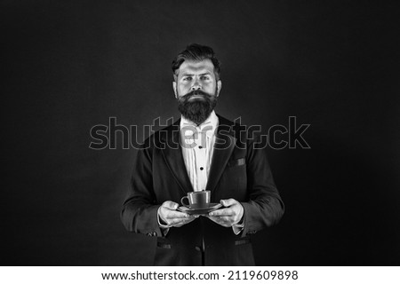 Caffeine loading please wait. Serious butler hold coffee cup. Bearded man with hot drink. Caffeine energy. Morning and breakfast. Caffeine addiction. Caffeine addict. Coffee shop, vintage filter Royalty-Free Stock Photo #2119609898