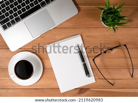 Laptop, Notebook and Coffee Mug on Home Office Desk. Wood Background 