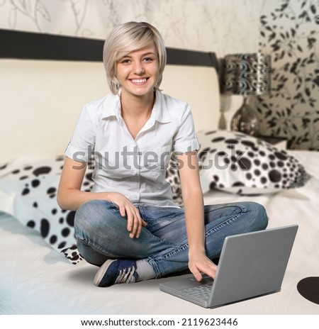 Young happy smiling female student watching an online class on laptop computer