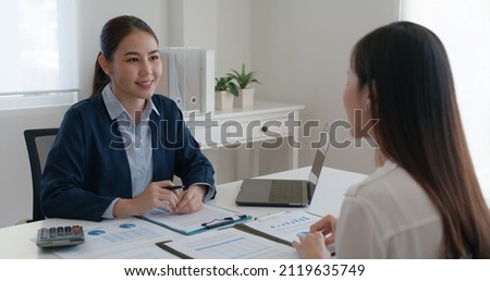 Asia woman real estate sale agent or trader advice sitting at lawyer office desk  smile trust talk in wealth service legal tax consult. HR people brief or coach for happy work plan in bank loan job.  Royalty-Free Stock Photo #2119635749