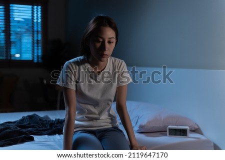 Young Asian woman suffer from insomnia can't sleep at night awaken from stress mental health problem or migraine. Young people health care psychiatry concept. Woman sitting on bed can't sleep at night Royalty-Free Stock Photo #2119647170