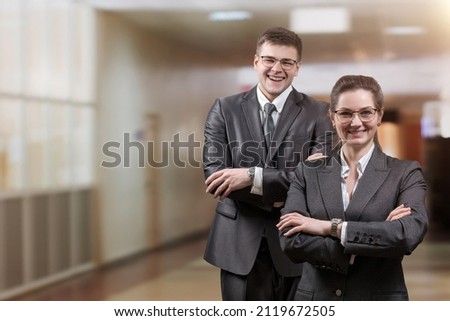 Man and woman in business suits on a blurred background.