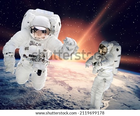 Astronauts above earth. The elements of this image furnished by NASA.

