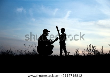 silhouette of father and son playing baseball on nature family sport concept