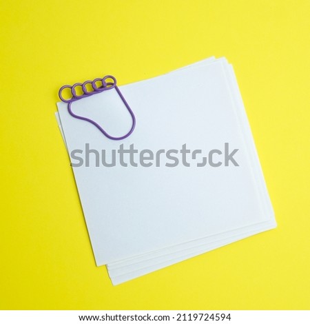White blank with a paperclip on a yellow background