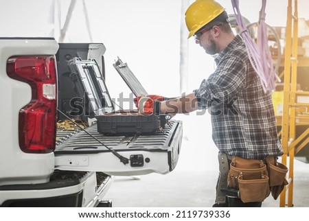 Caucasian Construction Worker Reading HVAC Assembly Plan and Documentation on a Site Next to His Modern Pickup Truck. Royalty-Free Stock Photo #2119739336