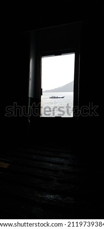 a boat passes right across from the emergency exit of a boat that is leaning in black and white