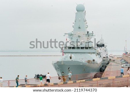 Two British warships doing training in harbour, some random people strolling around near ship. Sea. Water. Radar. UK. United Kingdom. Port Royalty-Free Stock Photo #2119744370