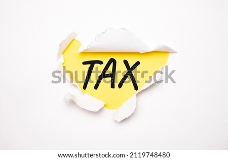 Torn white paper lies on a bright yellow background with the text TAX