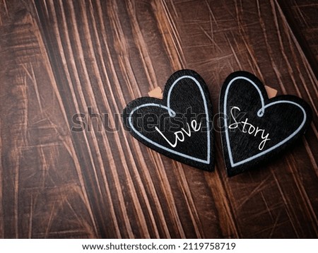 Top view wooden love board with text Love Story on a wooden background.