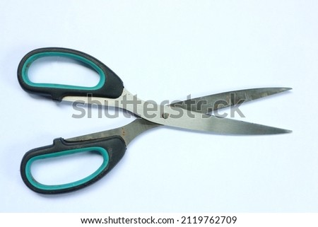 Stainless metal scissors with black rubber hand grip on a white background