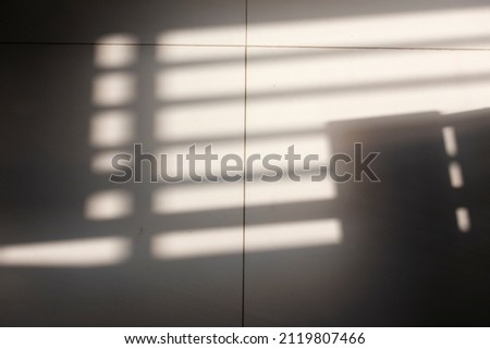 Abstract light and shadow on the tiled floor.
