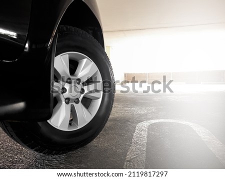 Pickup truck tires and alloy wheels, side view of pickup trucks parked on a parking lot There was a light shining on the side of the picture