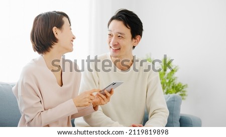 A couple doing research on their smartphone. Royalty-Free Stock Photo #2119819898