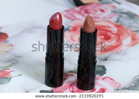 Lipstick displayed on front of floral decorative paper