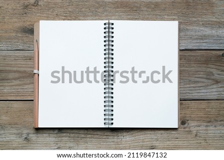 Notebook with a wooden pencil on wooden table background, close up