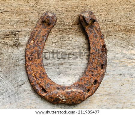 the old rusty horseshoe hangs on a wooden board