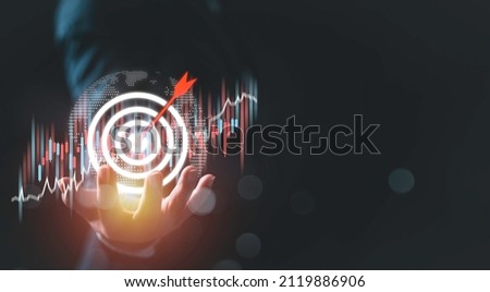 Businesswoman holding red arrow dart to virtual target dart board. Setup objectives and target for business investment concept, Digital marketing, Business goal and technology concept. Royalty-Free Stock Photo #2119886906