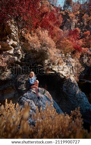 Active lifestyle. Trekking and hiking. Young woman with rucksack in the forest rock canyon.