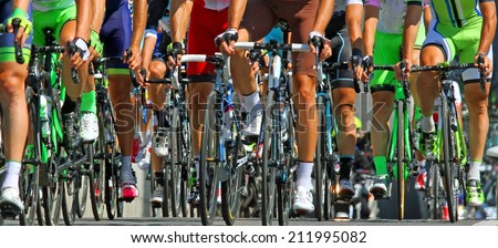muscular legs of cyclists who ride during the international race Royalty-Free Stock Photo #211995082