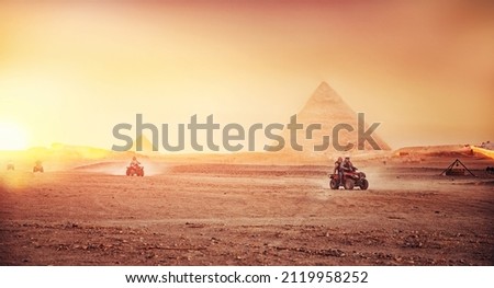Quad bikes ATV safari in desert background Pyramids Sphinx Cairo, Egypt.