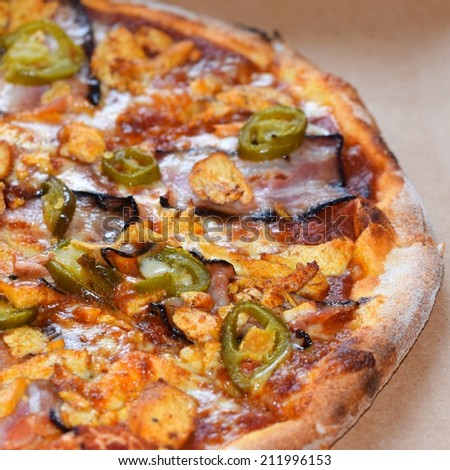 Delicious italian pizza with bacon, jalapenos, vegetables and chicken.