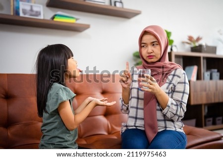thirsty young daughter ask mother to drink a glass of water Royalty-Free Stock Photo #2119975463