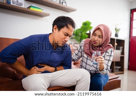 asian young couple drinking a glass of water during ramadan Royalty-Free Stock Photo #2119975616