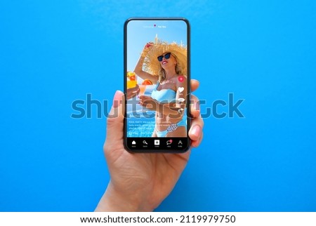 Mobile phone on blue background with shared video on sample social media app