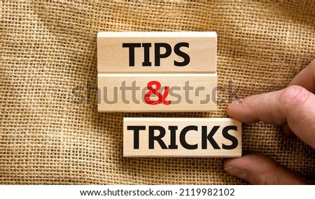 Tips and tricks symbol. Concept words Tips and tricks on wooden blocks. Beautiful canvas table canvas background. Businessman hand. Business, tips and tricks concept. Copy space.