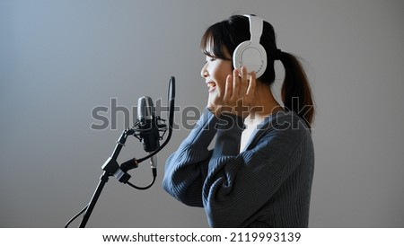 A young woman recording a song.	 Royalty-Free Stock Photo #2119993139