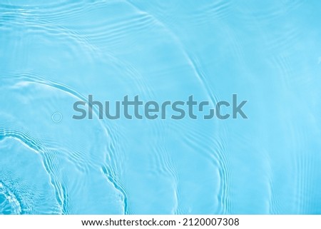 Transparent blue colored clear water surface texture with ripples, splashes and bubbles. Abstract nature background Water waves in sunlight with copy space Cosmetic moisturizer micellar toner emulsion Royalty-Free Stock Photo #2120007308