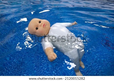 doll - baby drowns in blue water 