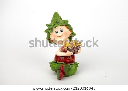 Beautiful souvenir toys.  the toys are made of porcelain. ceramics. and plaster. with rhinestones. toy girl -brownie, dwarf. On an isolated white background. close-up.