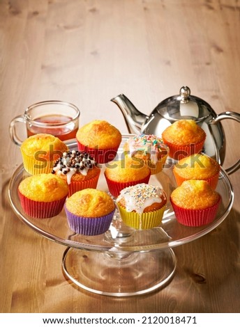 yellow muffins with sprinkles and tea .