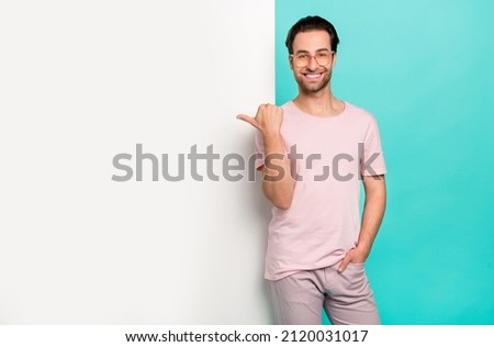 Photo of young man promoter indicate thumb empty space promotion ads choice isolated over turquoise color background
