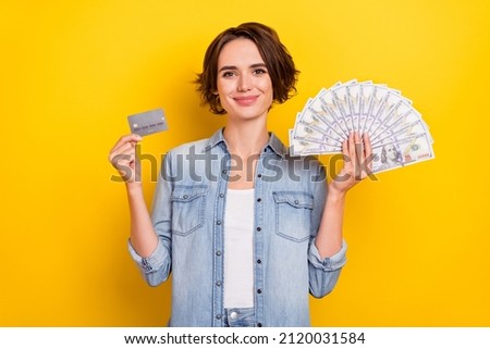 Photo of young woman hold bank card cash savings profit advetrise isolated over yellow color background