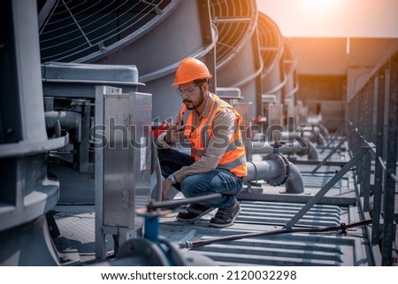 Industry engineer under checking the industry cooling tower air conditioner is water cooling tower air chiller HVAC of large industrial building to control air system. Royalty-Free Stock Photo #2120032298