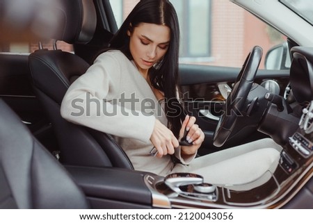 Young brunette caucasian woman driver in casual clothes fasten seat belt in car, preparing for driving. Road safety Royalty-Free Stock Photo #2120043056