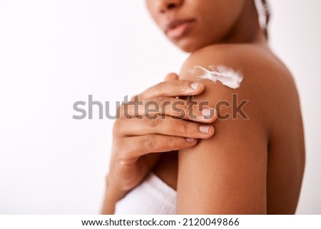 Beauty is as beauty does. Studio shot of an unrecognizable woman putting moisturiser on her body. Royalty-Free Stock Photo #2120049866
