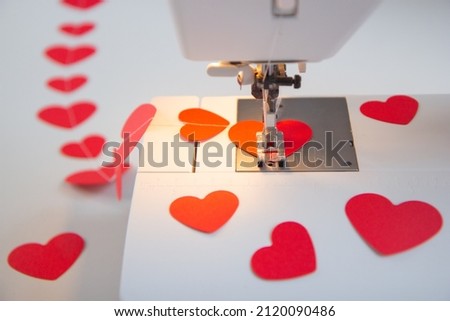 Making a garland of red hearts on a sewing machine