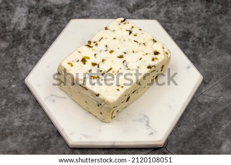 Cheese with herbs on a dark background. Minced goat feta cheese with herbs. Traditional Mediterranean cheese. Local name otlu peynir Royalty-Free Stock Photo #2120108051
