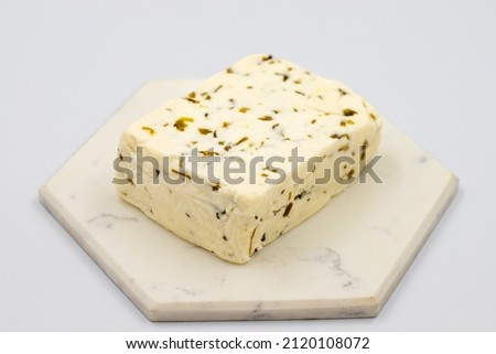 Cheese with herbs on a white background. Minced goat feta cheese with herbs. Traditional Mediterranean cheese. Local name otlu peynir Royalty-Free Stock Photo #2120108072