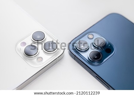 white and blue smartphone lies with cameras up on a white background Royalty-Free Stock Photo #2120112239