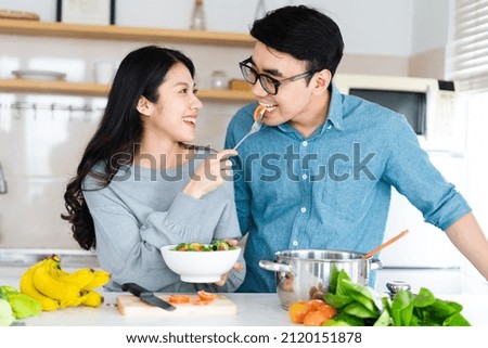 image of newlywed couple cooking at home Royalty-Free Stock Photo #2120151878