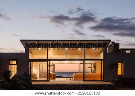 Illuminated luxury home under sky at dusk