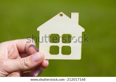 hand with wood house