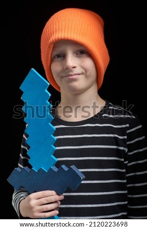 Portrait of a boy in a hat and a sword on a dark background