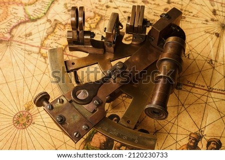 Vintage sextant on old map. Old style background.