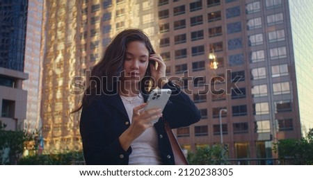 Young woman make photo beautiful town on smartphone. Attractive asian girl using phone taking pictures cityscape on weekend megapolis. Pretty tourist holding modern gadget watching screen close up.